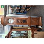 A 1920s oak longcase clock having round dial, 8 day, the glazed door having fretwork decoration, 220