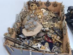 A tray of World War II era military metal cap badges, some earlier examples and sundry