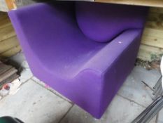 A modern corner chair of square shape with purple upholstery