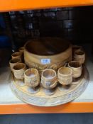 A carved wooden punch bowl with matching cups on circular base, and sundry