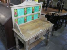 A stripped pine 2 drawer wash stand having tiled back