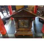 An early 20th Century, oak mantle clock having carved decoration with arched top with pendulum and k