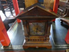 An early 20th Century, oak mantle clock having carved decoration with arched top with pendulum and k