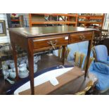 An early 20th Century mahogany two drawer writing table on square tapered legs