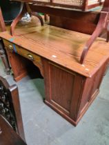 An early 20th century, pitch pine school teachers desk having one drawer beside cupboard