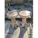 A pair of rustic wooden plant stands and a cast iron wheel