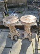 A pair of rustic wooden plant stands and a cast iron wheel