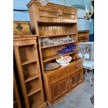 An old stripped pine dresser, the rack back having top cupboard