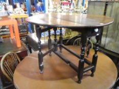 An antique two flap gateleg table having one drawer and a set of 4 ladderback chairs