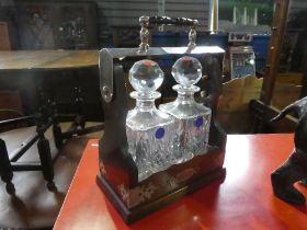 A modern mahogany Tantalus, having 3 crystal decanters