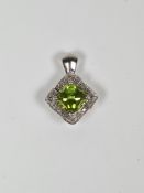 Contemporary 9ct white gold pendant with central cushion cut peridot surrounded 16 small diamonds in