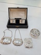 A cased pair of silver napkin rings by Turner and Simpson, with two silver decanter labels. Also wit