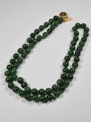 Single row of Jade circular beads with silver gilt clasp, 65cm