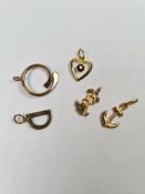 Five 9ct gold charms/pendants including anchor, 'D' garnet set heart shaped example, dog and circula