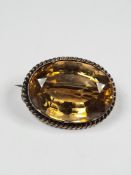 Unmarked yellow metal oval brooch with large mixed cut Citrine, with ropetwist frame, 2.5cm