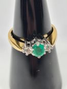 18ct yellow gold dress ring with central oval cut emerald with two brilliant round cut diamonds, siz