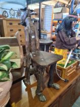 An African carved wooden chair in form of seated man with tilted back head