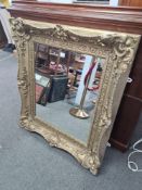 A Victorian oblong gilt wall mirror having plaster decoration of flowers, 110cm