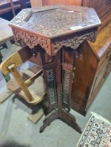 A Burmese carved plant stand having hexagonal top