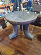 A carved wooden African stool, probably Ethiopian on 3 shaped supports, 43.5cm