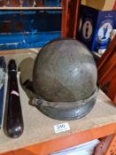 A post World War II M1 helmet and a wooden truncheon