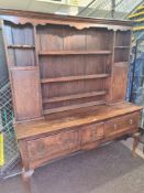 An antique oak dresser having 3 drawers on front cabriole legs with rack back, 175.5cm