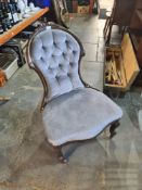 A Victorian button back nursing chair having carved back rail
