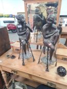 A pair of matching modern bronze figures of seated ladies on stools