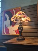A modern bronze style table lamp having floral shade