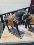 A pair of Victorian style black and gilt decorated wooden horses possibly from a Fairground, 84cm