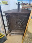 An old carved oak corner cupboard decorated birds and foliage