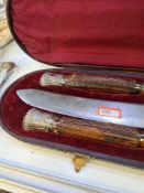 A cased carving set having Stag handles, with silver ends and collar. Decorative foliate design and