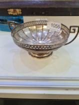 A Harrods decorative silver bon bon dish having two handles, circular pedestal base and decorative p