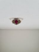 18ct yellow gold ruby and diamond cluster ring, with central oval cut ruby in 4 claw mount, surround
