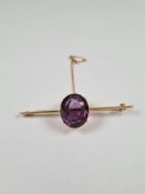Unmarked yellow metal, 18ct brooch with sword edge bar mounted with a large oval mixed cut amethyst,