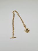 9ct yellow gold figaro design neckchain with T-bar, hung with a circular pendant dated 1933, depicti
