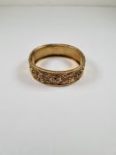 Victorian yellow metal, possibly 15ct thick hinged bangle, the top half with raised floral decoratio