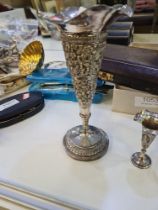 Decorative white metal items to include a heavily embossed trumpet vase, the body decorated with flo