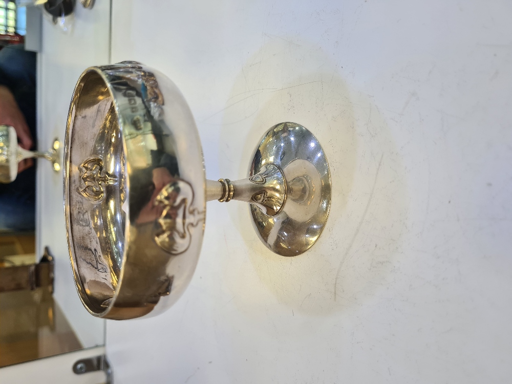 An art Nouveau silver dish standing on a domed circular foot. The tall stem having embossed details,