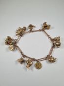 Impressive 9ct yellow gold charm bracelet hung with 12 charms to include:- a ring box that opens to