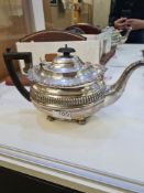 A silver tea service comprising a large silver teapot having decorative, embossed gadrooned borders