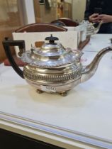 A silver tea service comprising a large silver teapot having decorative, embossed gadrooned borders