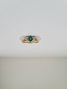 18ct yellow gold dress ring with central oval emerald and a brilliant cut diamond each side, size M,