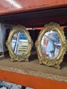 A pair of reproduction gilt oval easel mirrors