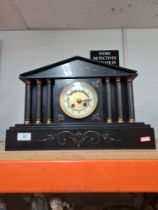 A Victorian black slate mantle clock with arched top and pillars, 29cm