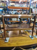 A 1960s/70s teak tea trolley having sliding tray with slatted undertier, possibly Danish, retailed f