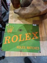 An enamel sign advertising Rolex watches