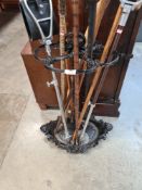 An old Victorian style cast iron stick stand and various sticks