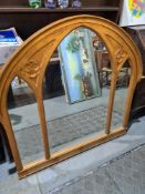A reproduction gilt overmantle mirror having arched decoration