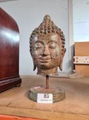 A reproduction Thai style metal Buddha head on circular base, 26cm